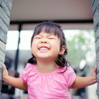 Kid smiling with her eyes closed