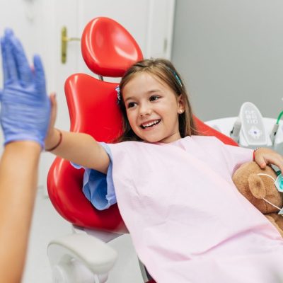 Child giving dentist high five